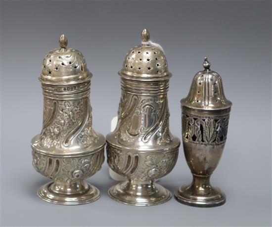 A pair of Victorian silver pepperettes, G.M. Jackson, London, 1882 and a later Edwardian silver pepperette.